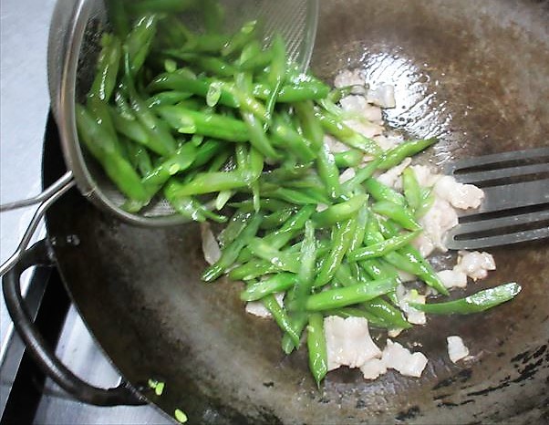 豚肉にさやいんげんを加える